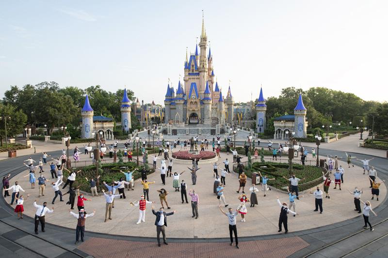 Josh D’Amaro, chairman, Disney Parks, Experiences and Products (center front right) and Jeff Vahle, president, Walt Disney World Resort (center front left), pose with Disney cast members for a photo in front of Cinderella Castle, July 11, 2020, prior to the phased reopening of Magic Kingdom Park at Walt Disney World Resort in Lake Buena Vista, Fla. (David Roark, photographer)