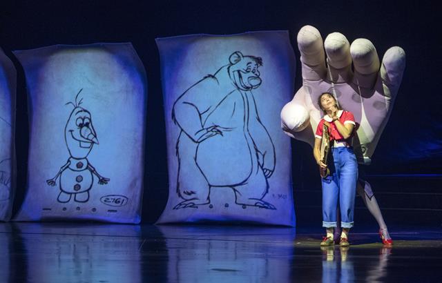 Mainamie, the white gloved hand, comforts Julie on her journey through the world of Disney animation in Drawn to Life, the highly anticipated new collaboration from Cirque du Soleil and Disney. The show premiered on Nov. 18, 2021, at Walt Disney World Resort in Lake Buena Vista, Fla. (Kent Phillips, photographer).